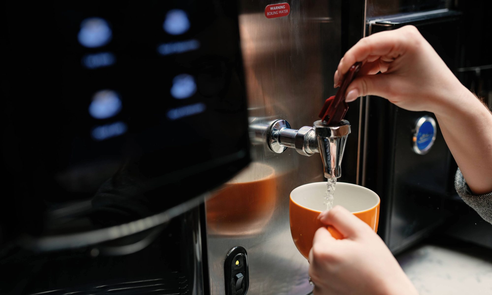 Someone pouring water from a water boiler