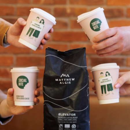 Bag of Matthew Algie coffee beans surrounded by Social Bite takeaway cups