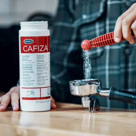 Man using Cafiza coffee cleaner to coffee machine 